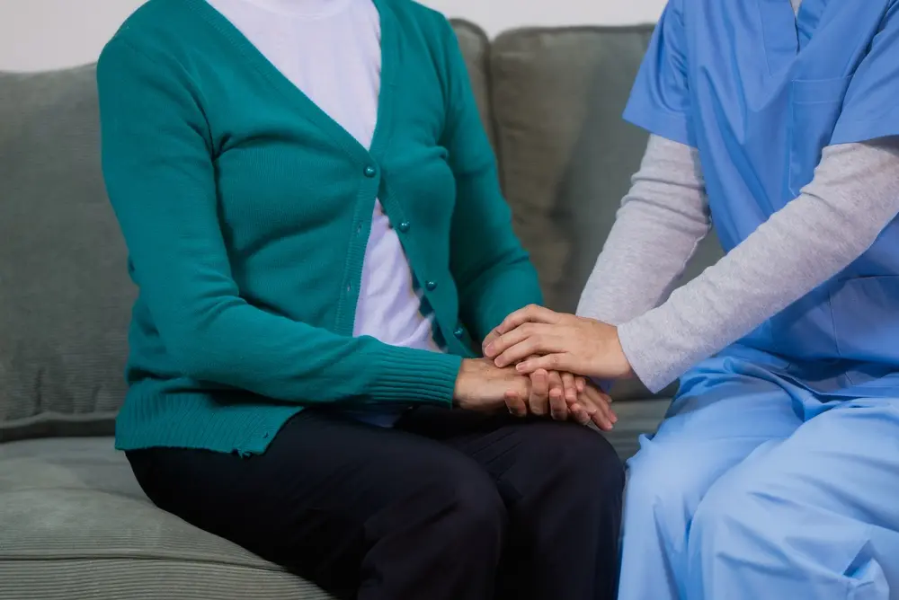 Nurse holding an elderly woman’s hands during personalized skilled nursing care and recovery support